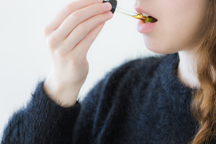 woman taking cannabis tincture